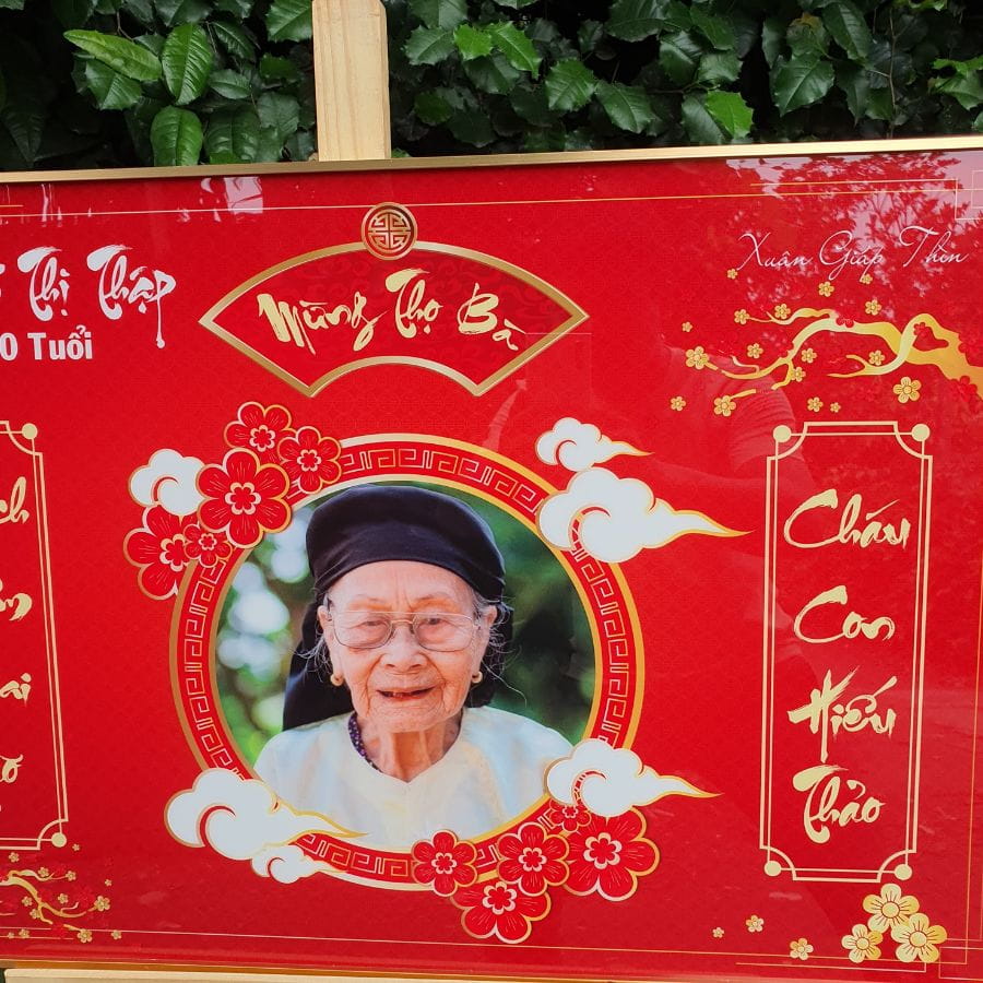 Hình ảnh bà và thông tin tên tuổi được in lên mẫu tranh mừng thọ G6